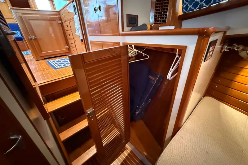 Slide: The Image of Interior of 2002 Grand Banks 42 Classic yacht with open wooden closet and stairs. - 27