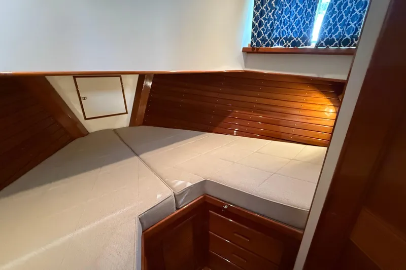 Slide: The Image of 2002 Grand Banks 42 Classic cabin with wooden paneling and cozy bedding. - 30