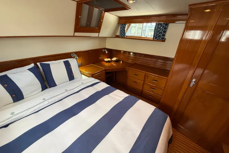 Slide: The Image of Luxurious cabin interior of 2002 Grand Banks 42 Classic yacht with wood finish and striped bedding. - 39