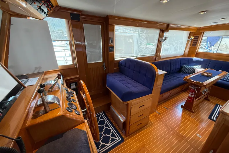 Slide: The Image of Interior of 2002 Grand Banks 42 Classic yacht with wooden finish and blue seating. - 4