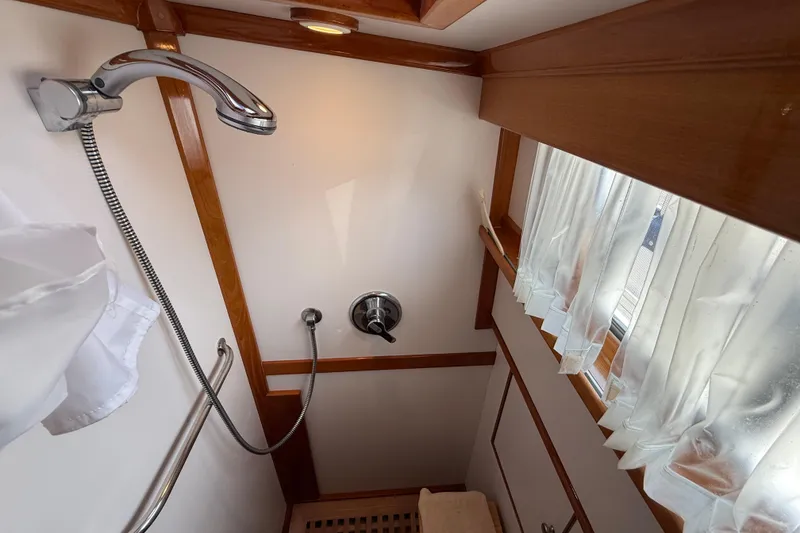 Slide: The Image of Shower area in 2002 Grand Banks 42 Classic yacht with wooden trim and window curtains. - 42