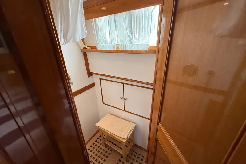 Slide: The Image of Interior of 2002 Grand Banks 42 Classic yacht, featuring wooden cabinetry and a window with curtains. - 43