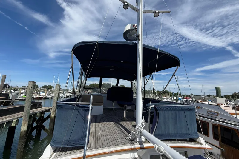 Slide: The Image of 2002 Grand Banks 42 Classic yacht docked at marina under clear blue sky. - 46