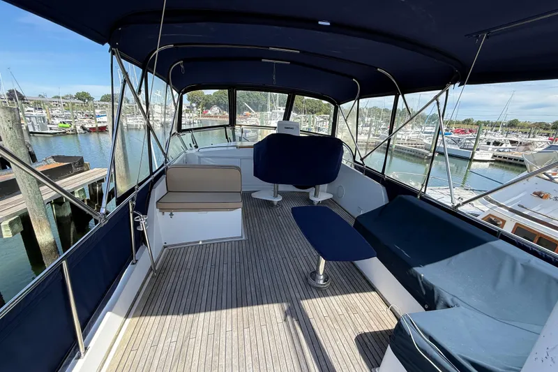 Slide: The Image of Flybridge of 2002 Grand Banks 42 Classic yacht with seating, docked at marina. - 48