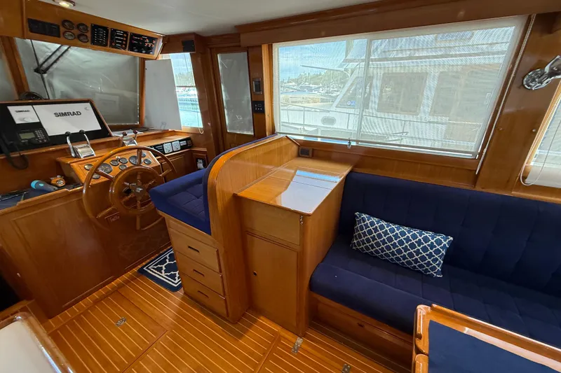 Slide: The Image of Interior of 2002 Grand Banks 42 Classic yacht with wooden helm and blue seating. - 5