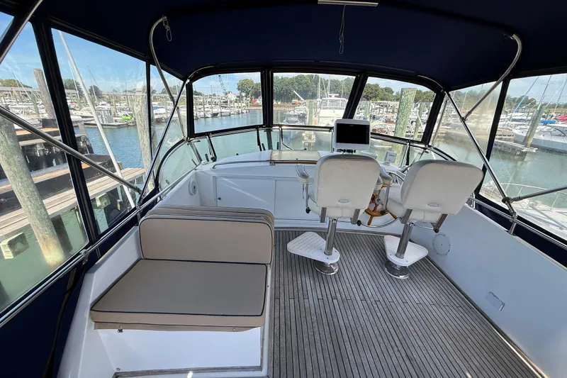 Slide: The Image of Grand Banks 42 Classic 2002 yacht helm with seating, overlooking marina. - 50