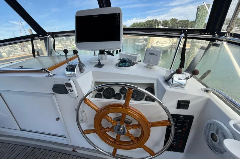 Slide: The Image of Helm of 2002 Grand Banks 42 Classic yacht with wooden wheel and navigation equipment. - 53