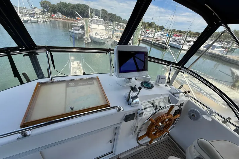 Slide: The Image of Helm of 2002 Grand Banks 42 Classic yacht, featuring navigation equipment and wooden steering wheel. - 55