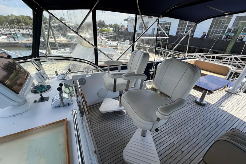 Slide: The Image of Flybridge of 2002 Grand Banks 42 Classic yacht with helm chairs and marina view. - 56