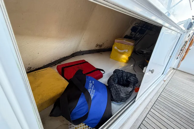 Slide: The Image of Storage compartment on a 2002 Grand Banks 42 Classic boat with various bags and equipment. - 57