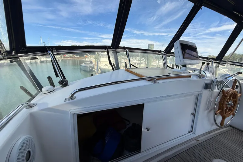 Slide: The Image of Grand Banks 42 Classic 2002 yacht helm with wooden wheel and marina view. - 58