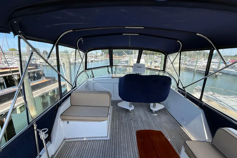 Slide: The Image of Flybridge of 2002 Grand Banks 42 Classic yacht, featuring seating and helm, docked at marina. - 59