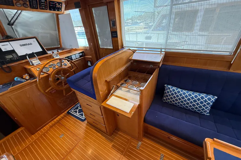 Slide: The Image of Interior of 2002 Grand Banks 42 Classic yacht with wooden helm and blue seating. - 6