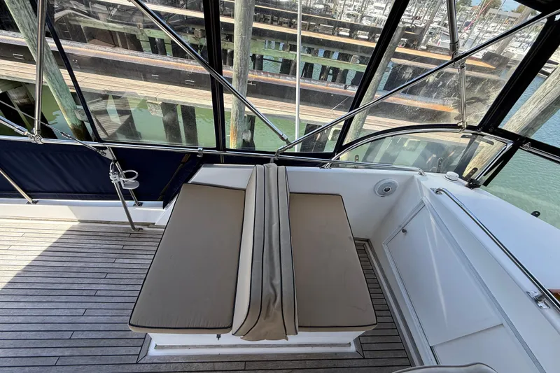 Slide: The Image of 2002 Grand Banks 42 Classic yacht with cushioned seating and teak deck, docked at marina. - 60