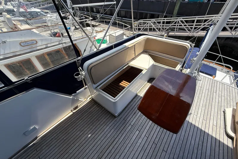 Slide: The Image of 2002 Grand Banks 42 Classic yacht deck with seating and wooden table. - 62