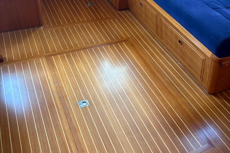 Slide: The Image of Teak flooring and blue cushioned seating in 2002 Grand Banks 42 Classic yacht interior. - 65