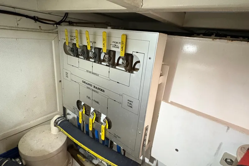 Slide: The Image of Engine room fuel panel of 2002 Grand Banks 42 Classic yacht with labeled valves. - 78
