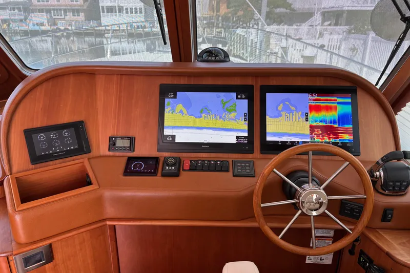 Slide: The Image of Helm of 2021 Sabre 48 Salon Express with navigation screens and wooden steering wheel. - 13
