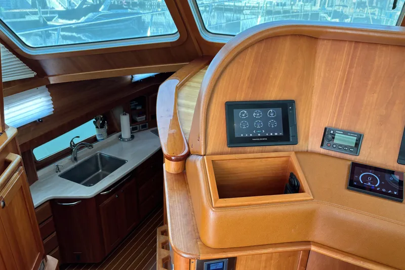 Slide: The Image of 2021 Sabre 48 Salon Express interior with wooden helm and modern kitchen area. - 15