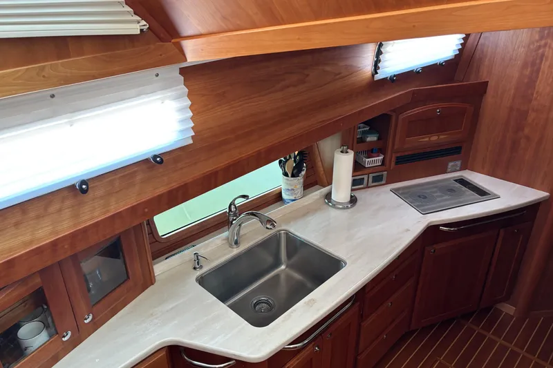 Slide: The Image of 2021 Sabre 48 Salon Express kitchen with sink, stove, and wooden cabinetry. - 16