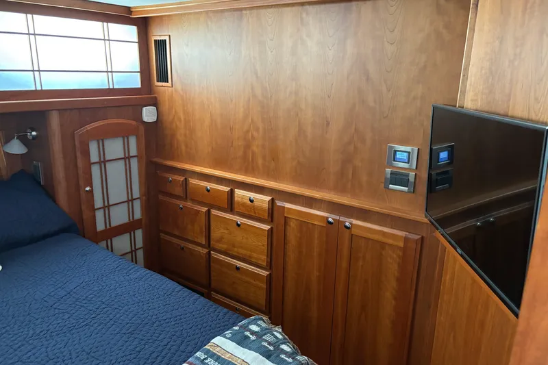Slide: The Image of 2021 Sabre 48 Salon Express cabin with wood paneling, bed, and wall-mounted TV. - 19