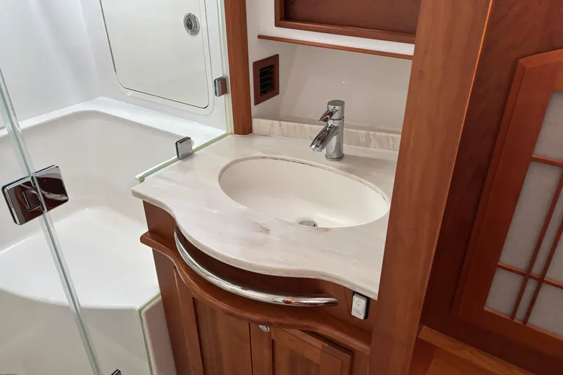 Slide: The Image of Luxurious bathroom sink in 2021 Sabre 48 Salon Express yacht, featuring elegant wood cabinetry. - 21