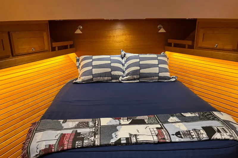 Slide: The Image of Cozy bedroom in 2021 Sabre 48 Salon Express yacht with striped pillows and nautical decor. - 23