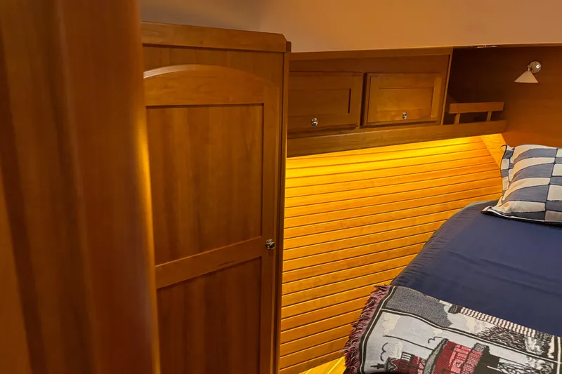 Slide: The Image of Cozy cabin interior of 2021 Sabre 48 Salon Express with warm wood paneling and ambient lighting. - 24