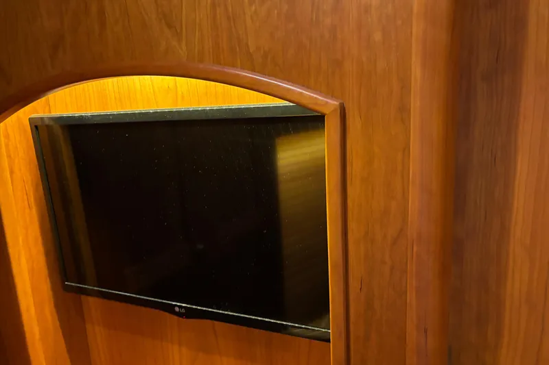 Slide: The Image of Wall-mounted TV in 2021 Sabre 48 Salon Express yacht interior with wooden paneling. - 26