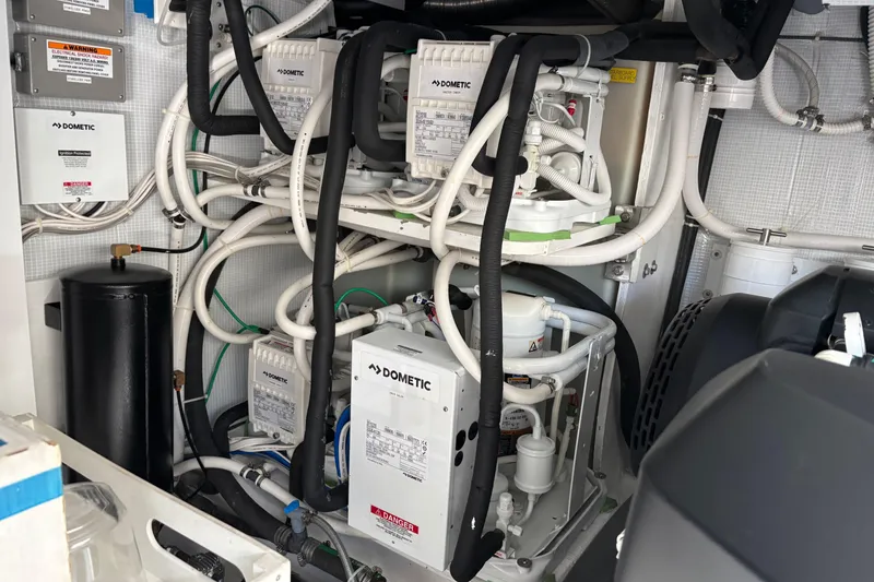 Slide: The Image of Engine room of 2021 Sabre 48 Salon Express with Dometic equipment and complex piping system. - 31