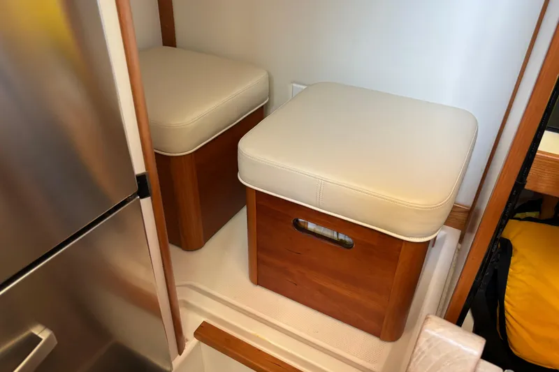 Slide: The Image of Interior seating area on 2021 Sabre 48 Salon Express yacht, featuring cushioned wooden stools. - 42