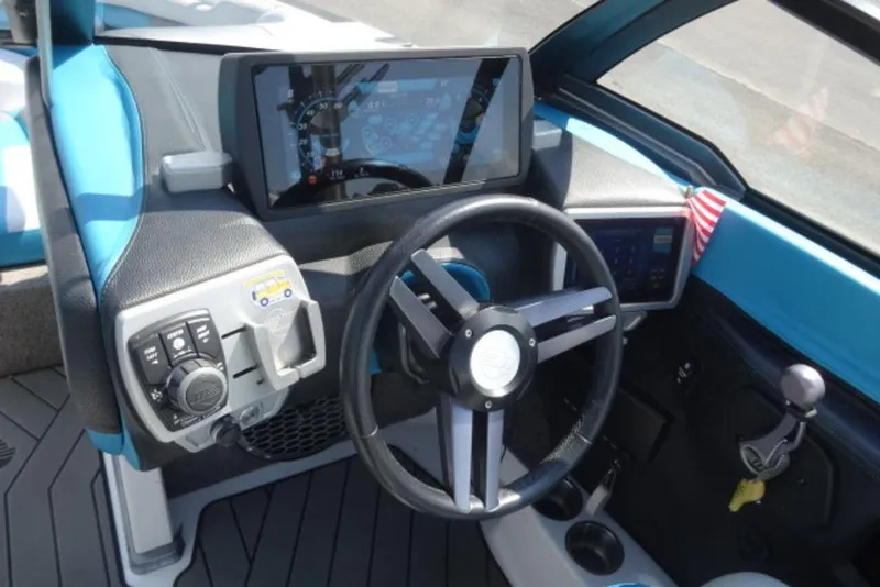 Slide: The Image of 2016 Malibu 25 LSV boat dashboard with steering wheel and control panel. - 15
