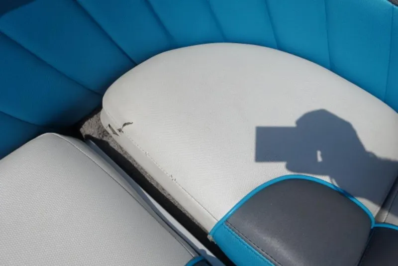 Slide: The Image of 2016 Malibu 25 LSV boat seat with minor tear, blue and white upholstery. - 17