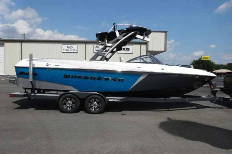 The Image of 2016 Malibu 25 LSV Wakesetter boat on trailer, parked outdoors. - 2