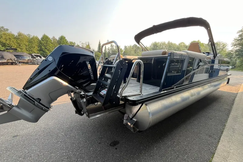 Slide: The Image of 2025 Avalon Catalina Quad Lounger pontoon boat with Mercury outboard engine, parked outdoors. - 4