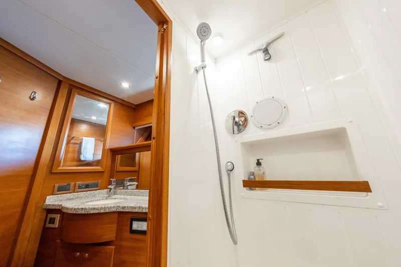 Slide: The Image of Luxurious bathroom in 2016 Grand Banks 72 Aleutian RP yacht with wood accents and granite countertop. - 107
