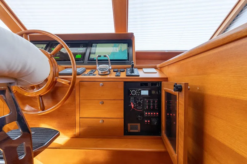 Slide: The Image of Helm of 2016 Grand Banks 72 Aleutian RP yacht with navigation screens and wooden wheel. - 72