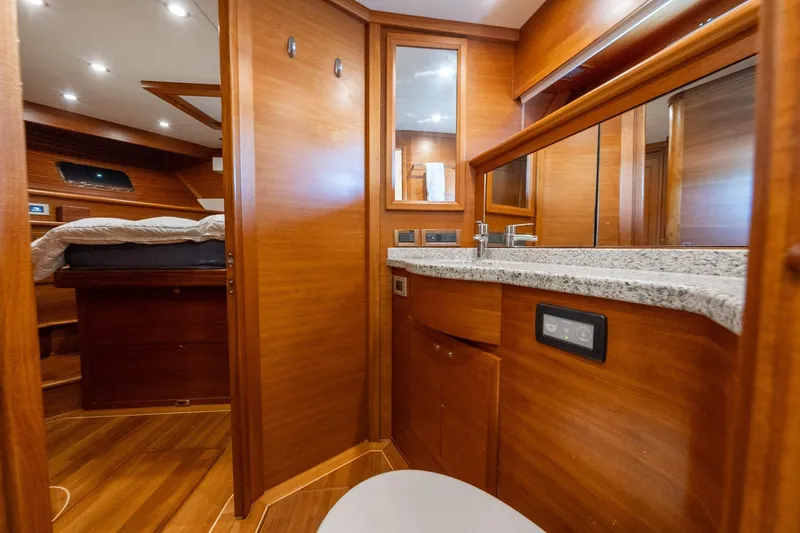Slide: The Image of Luxurious cabin interior of 2016 Grand Banks 72 Aleutian RP yacht, featuring wood paneling and cozy bedding. - 95