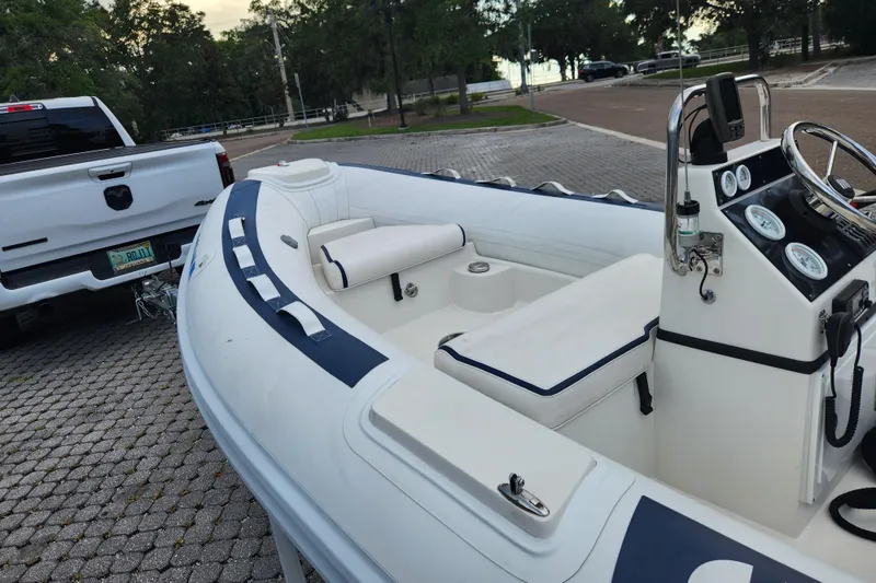 Slide: The Image of 2019 Novurania DL 400 boat hitched to a white truck in a parking area. - 12