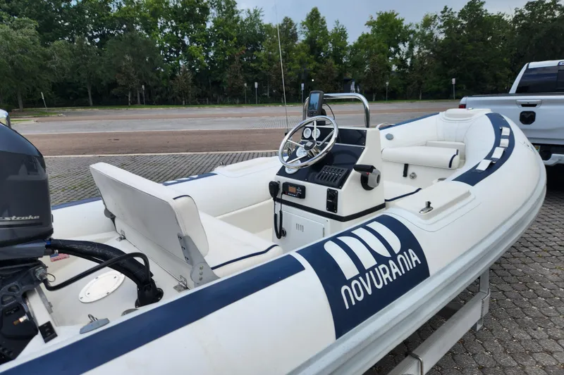 Slide: The Image of 2019 Novurania DL 400 boat with steering console, parked on a paved area. - 23