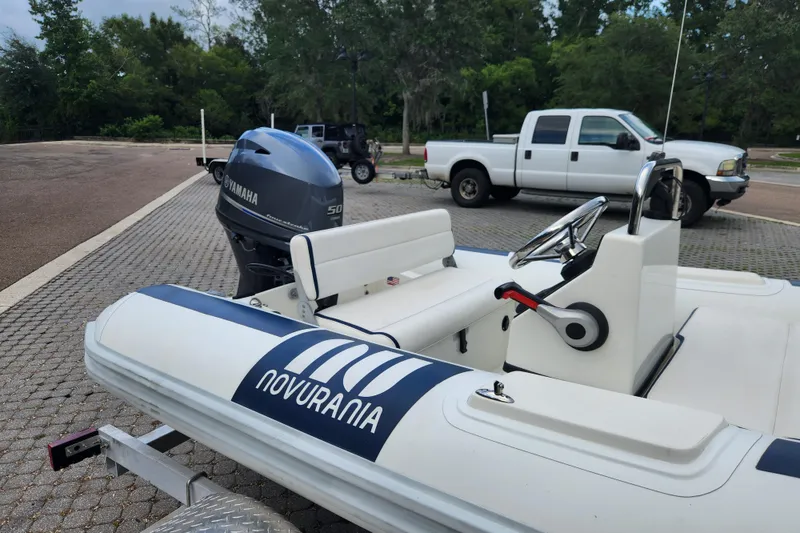 Slide: The Image of 2019 Novurania DL 400 boat with Yamaha engine on trailer, parked near white truck. - 24