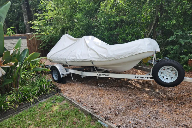 Slide: The Image of Covered 2019 Novurania DL 400 boat on trailer in garden setting. - 3
