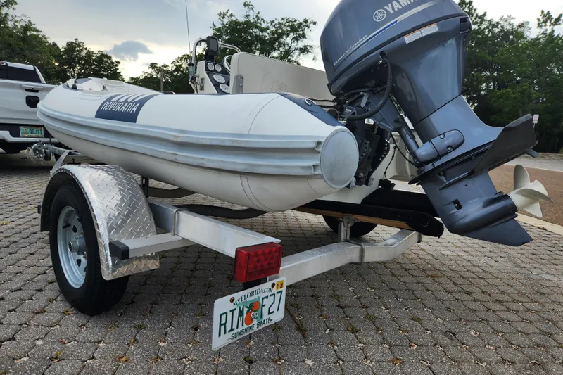 Slide: The Image of 2019 Novurania DL 400 boat on trailer with Yamaha outboard motor, parked outdoors. - 31
