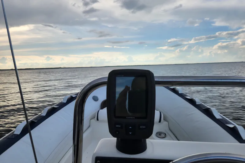 Slide: The Image of Novurania DL 400 boat with Garmin device, cruising on calm waters under a cloudy sky. - 54