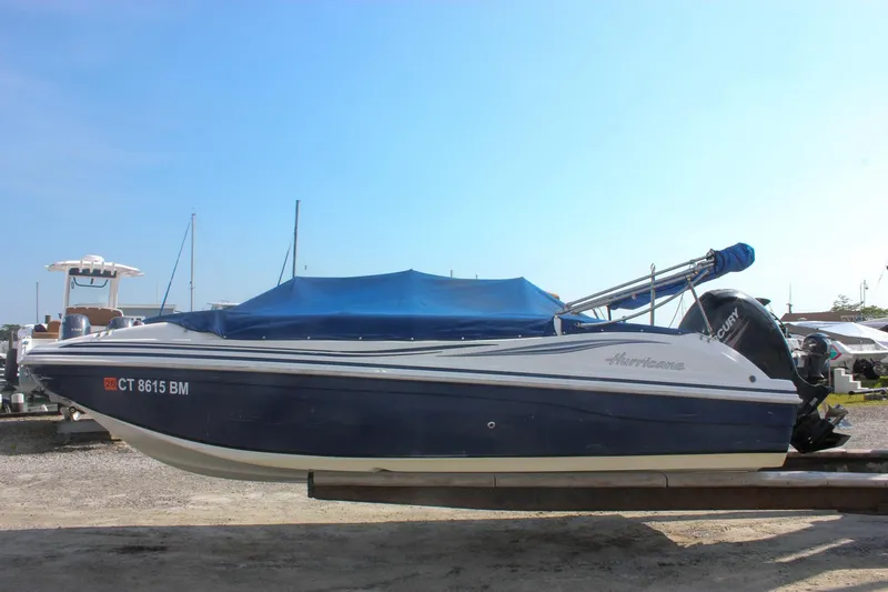The Image of 2013 Hurricane SunDeck Sport 188 OB boat with blue cover on trailer. - 0