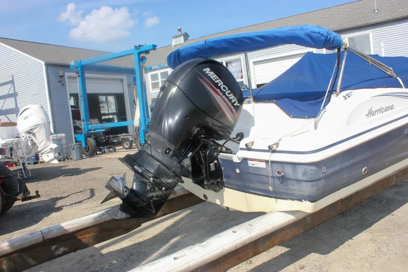 Slide: The Image of 2013 Hurricane SunDeck Sport 188 OB boat with Mercury outboard motor, docked outdoors. - 19