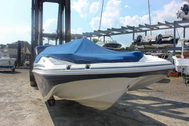 Slide: The Image of 2013 Hurricane SunDeck Sport 188 OB boat with blue cover, stored outdoors. - 2