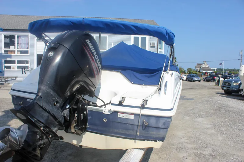 Slide: The Image of 2013 Hurricane SunDeck Sport 188 OB boat with Mercury outboard motor, blue canopy, parked outdoors. - 20