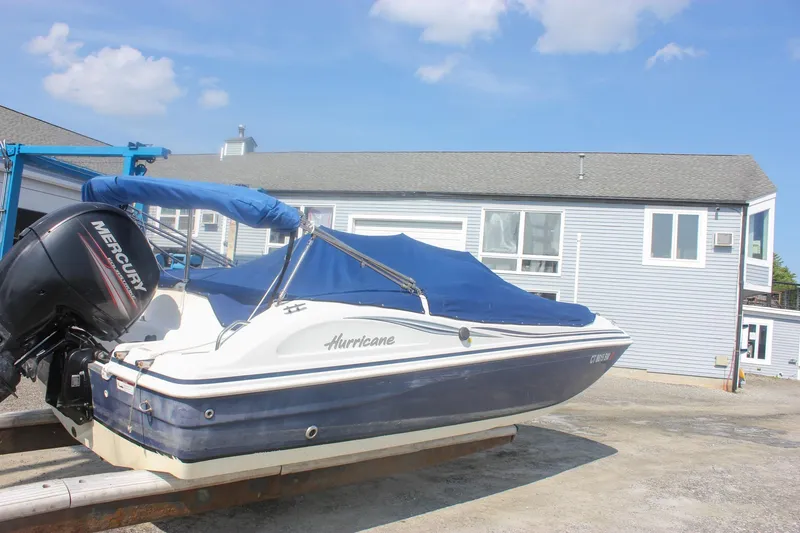 Slide: The Image of 2013 Hurricane SunDeck Sport 188 OB boat with blue cover and Mercury outboard motor. - 3