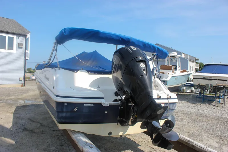 Slide: The Image of 2013 Hurricane SunDeck Sport 188 OB boat with blue canopy and outboard motor. - 4